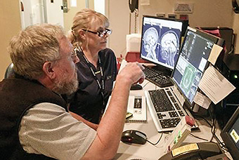 Dr. Stephen Dager and Mindy Dixon look over brain scans.