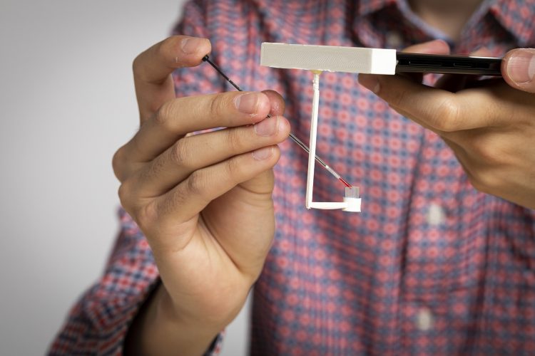picture of blood-clotting test device attached to smartphone