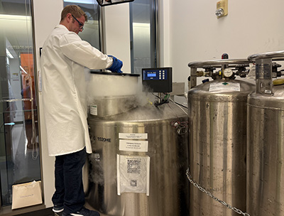 Adam Prince retrieves a lab sample from a freezer vat