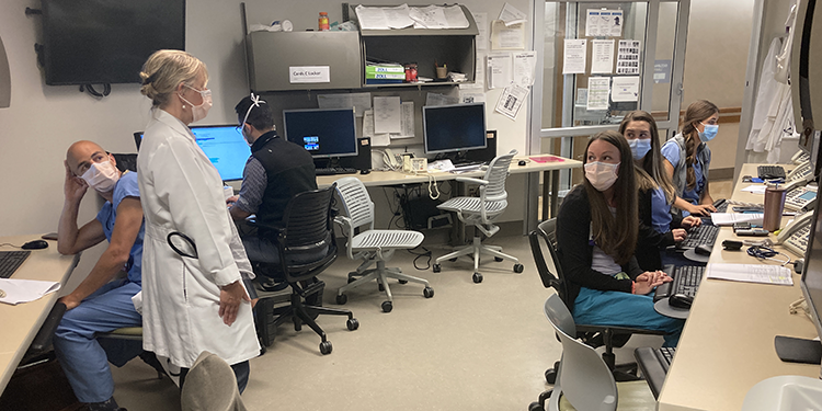 picture of Dr. April Stempien-Otero talking with the acute cardiac care team at UW Medical Center