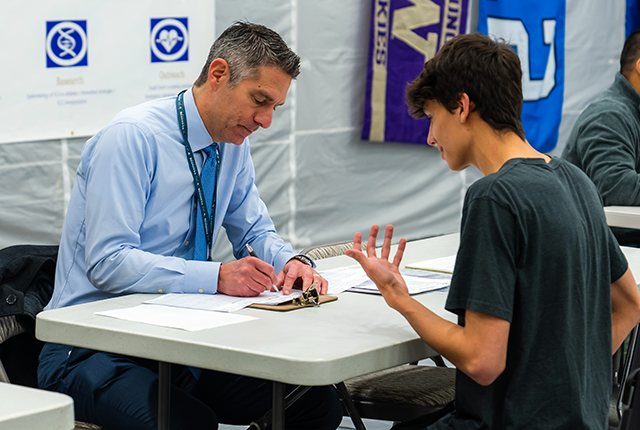 picture of Dr. Jonathan Drezner screening a high-schooler at a Nick of Time Foundation event