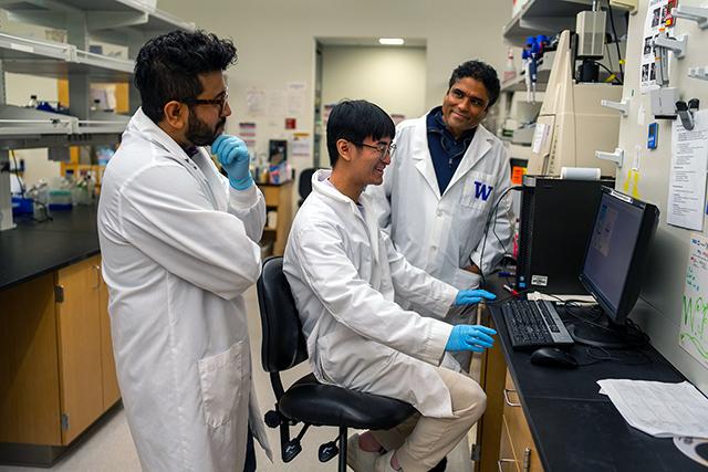 In the Ram Savan Lab in Immunology, Nandan Gokhale, Russell K. Sam, and Ram Savan review a gel image.