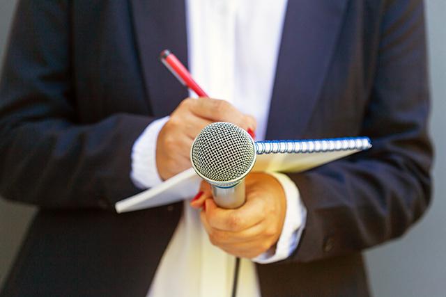 Reporter with notepad and microphone