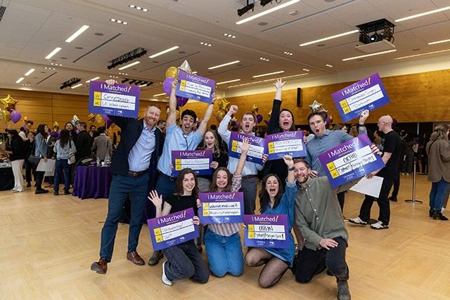 A group of UW medical students display their residency match placements at a Match Day celebration.