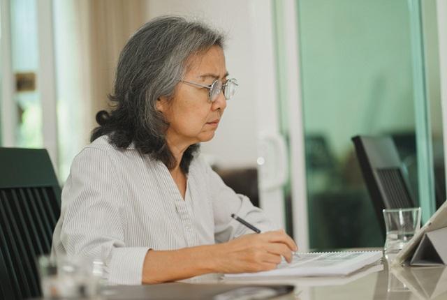 Woman looking thoughtfully at computer.