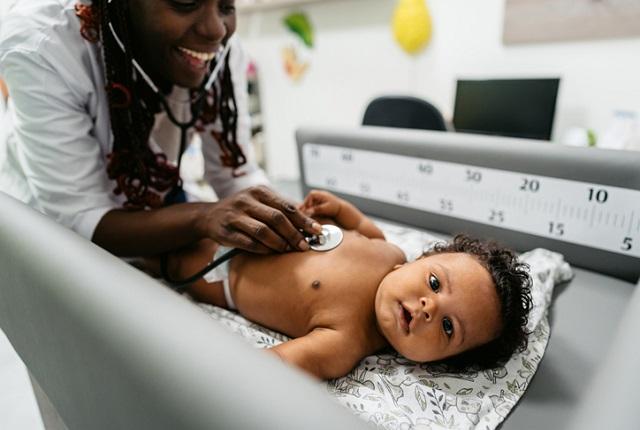 Young Black baby being examined in a clinic.