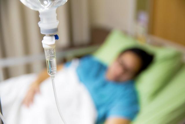 woman lying in bed with IV drip in forefront