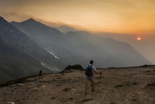 Man walking on a trail through wildfire smoke in Cascades.